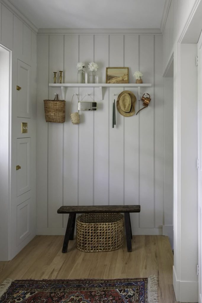 White shiplap mudroom with bench and wall hooks
