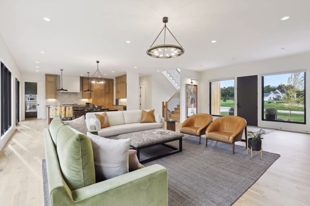 Modern open-concept living room with kitchen and large windows