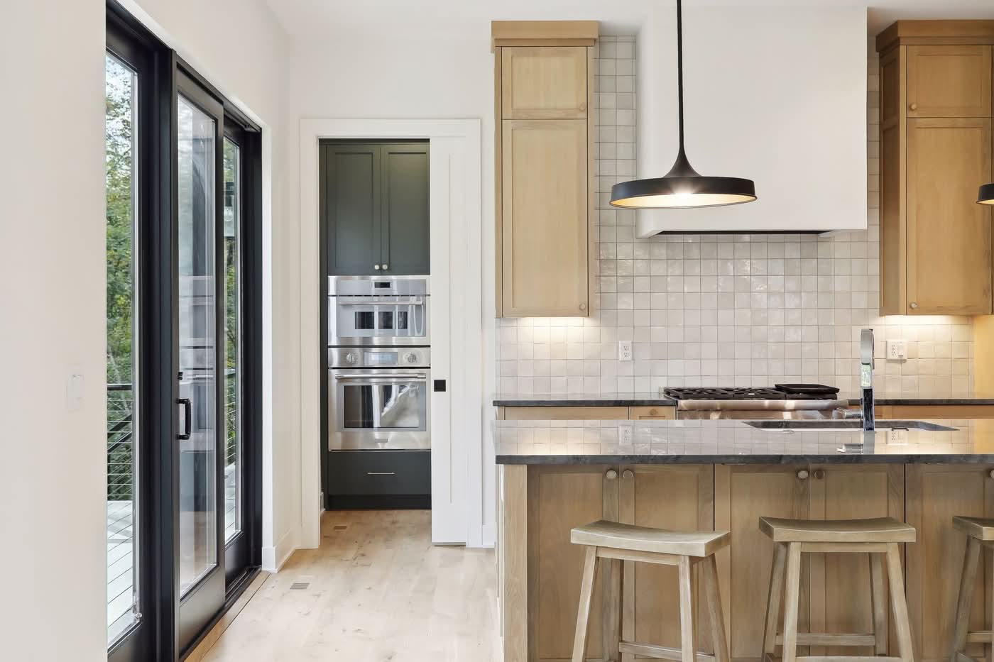 Modern kitchen with wooden cabinets and island stools