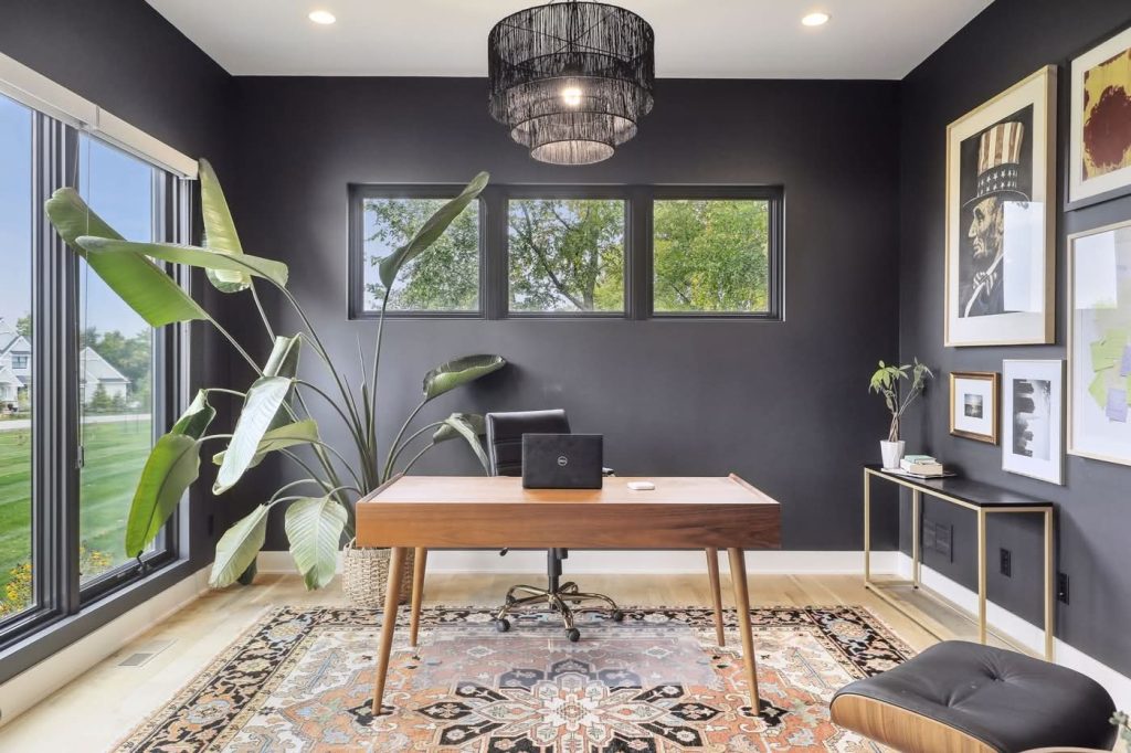 Modern home office with dark walls and wooden desk