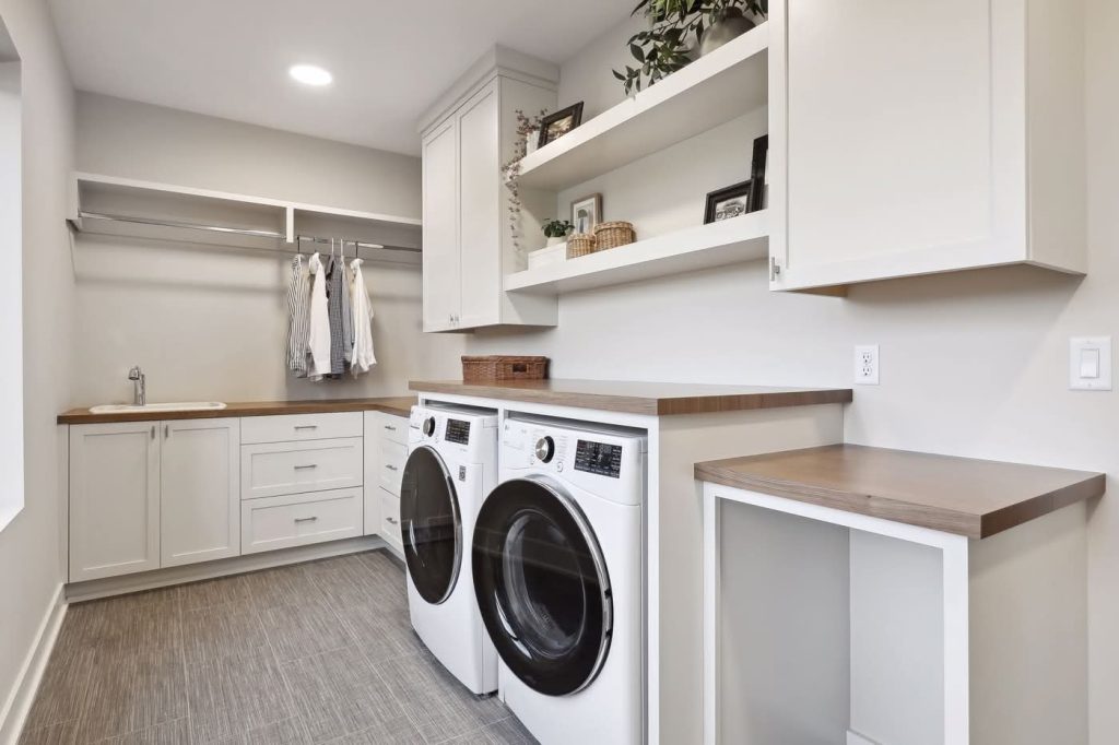 Modern laundry room with washer, dryer, and cabinets