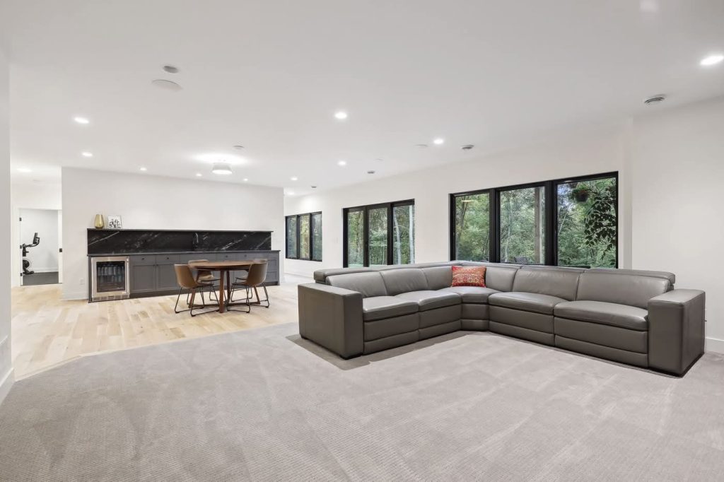 Modern living room with large sectional and forest views
