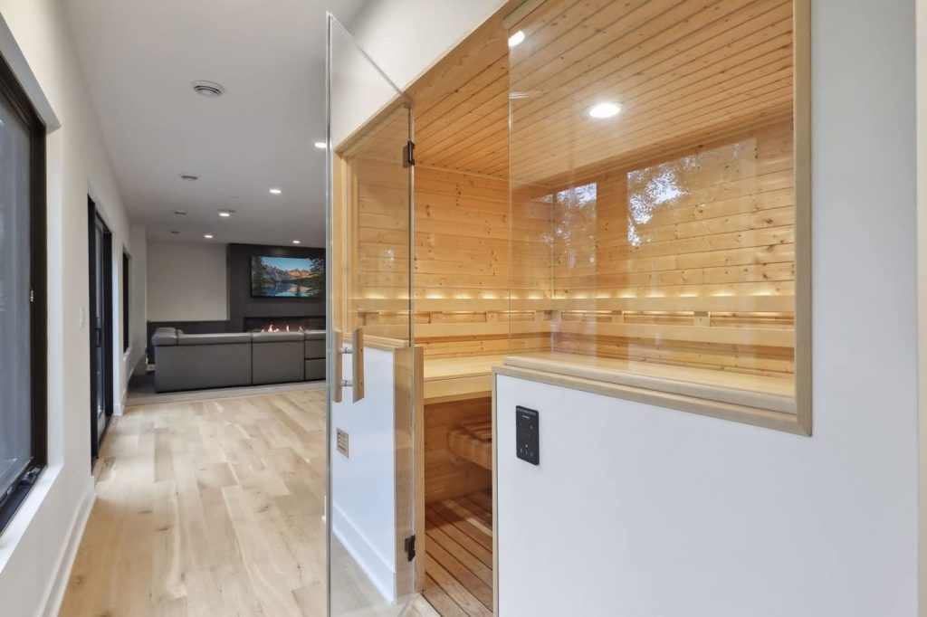 Modern indoor glass sauna next to living room