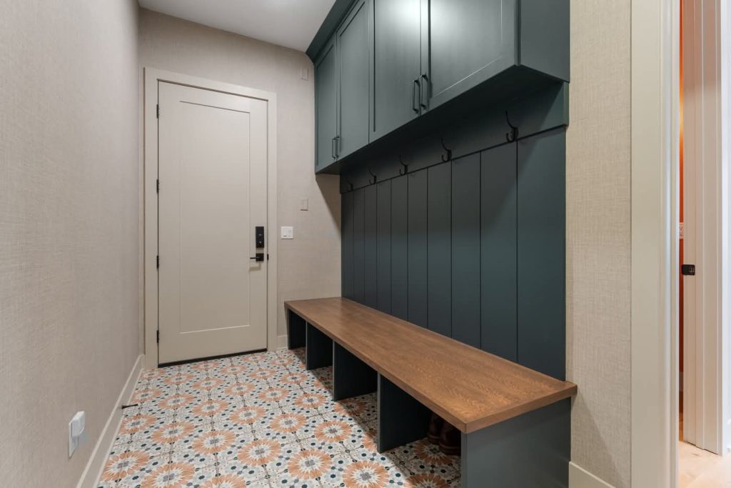 Modern mudroom with teal cabinets and patterned tile floor