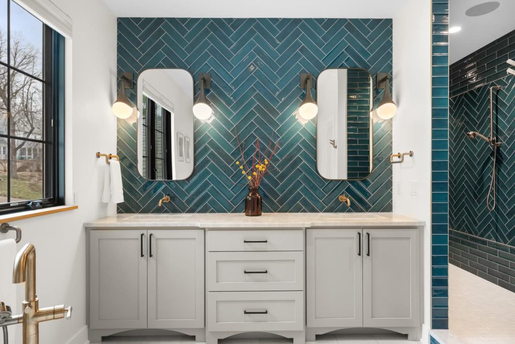 Modern bathroom vanity with teal herringbone tile backsplash