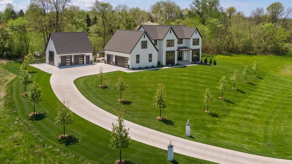 Modern farmhouse with large lawn and curved driveway