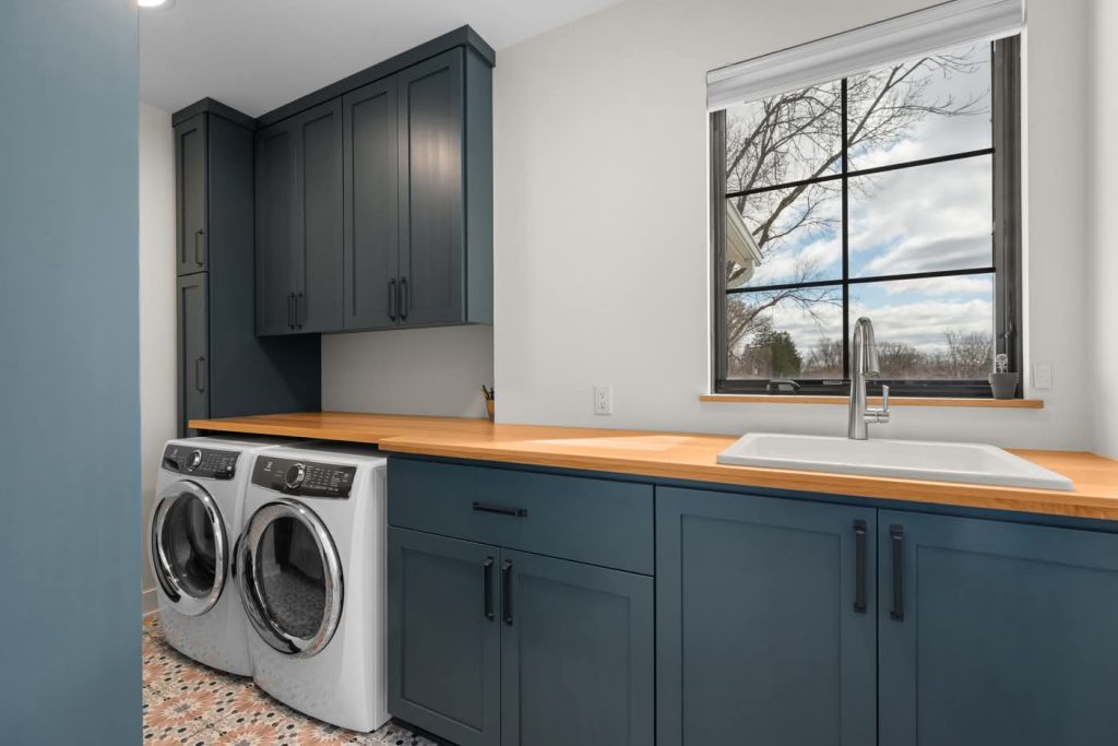 Modern laundry room with blue cabinets and washer dryer
