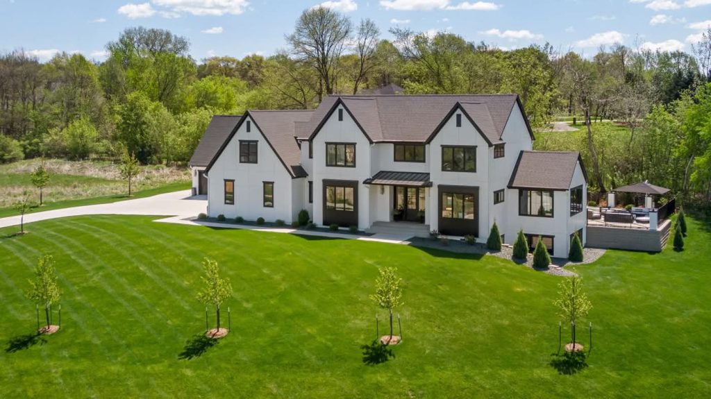 Modern white farmhouse with expansive green lawn