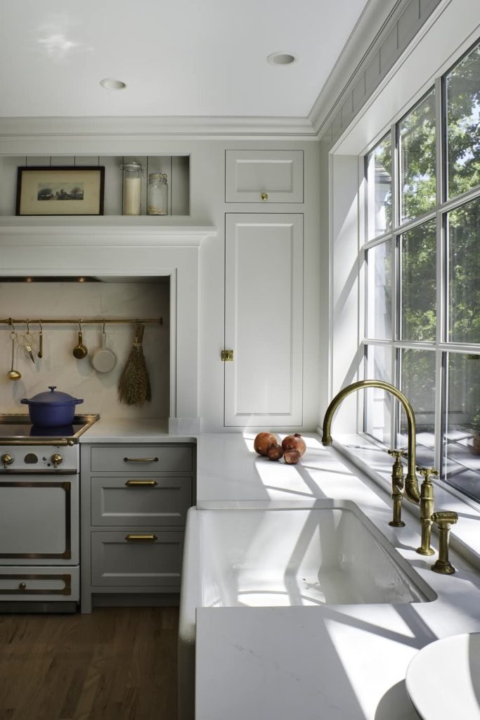 Bright farmhouse kitchen with brass faucet and window