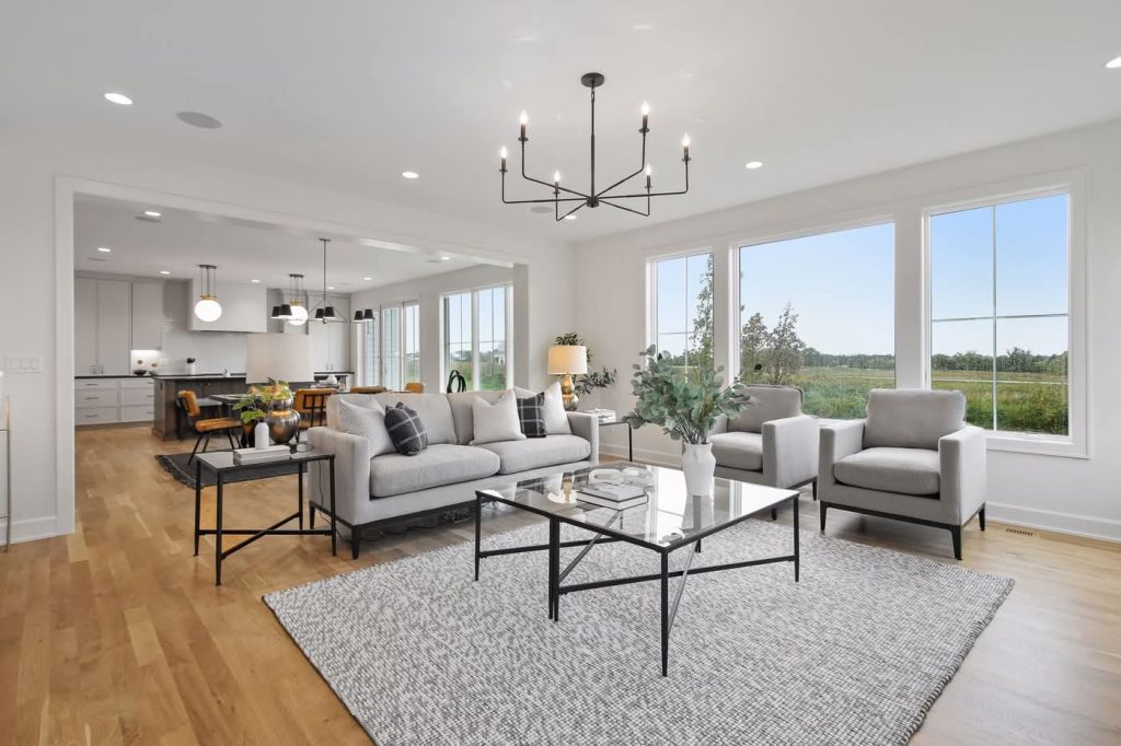 Modern open-concept living room with large windows and kitchen