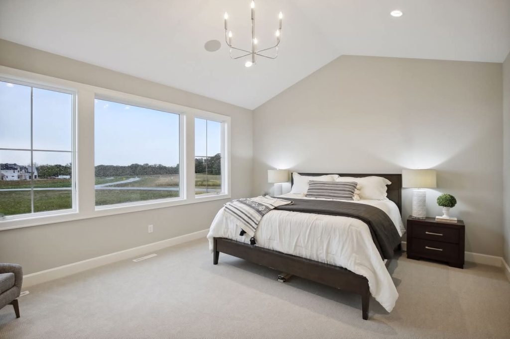 Spacious modern bedroom with large windows and neutral decor