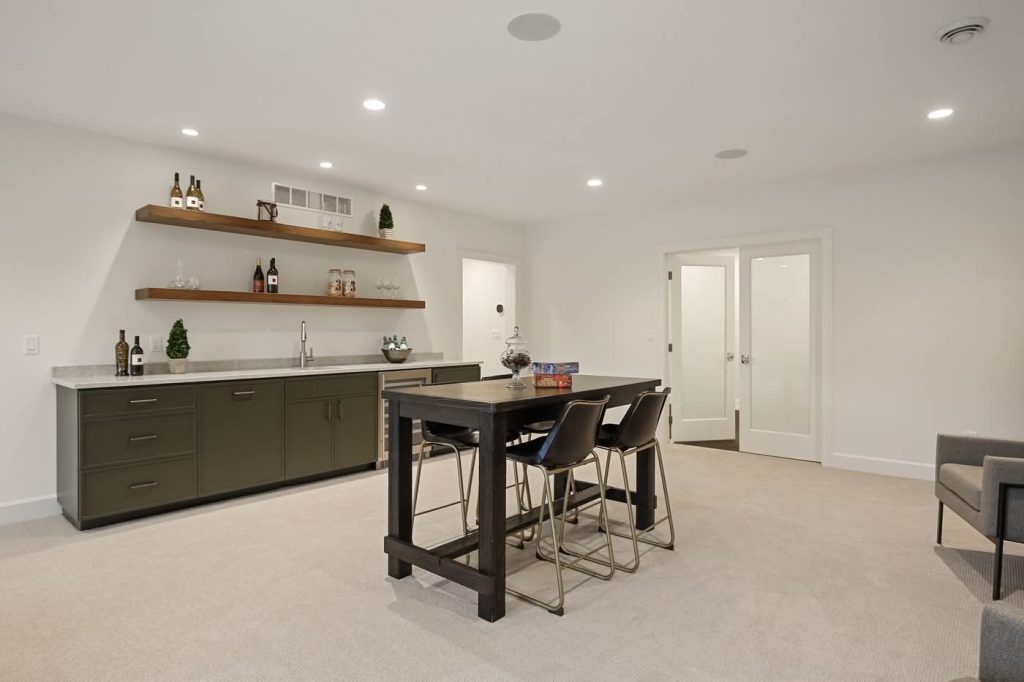 Modern basement bar area with table and shelves