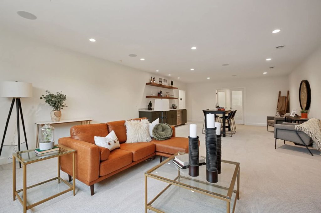 Modern living room with orange sectional and bar area