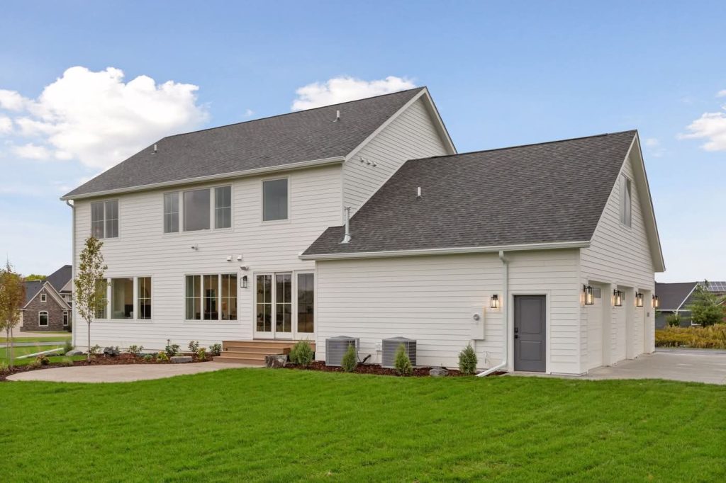 Modern two-story white house with attached garage and lawn