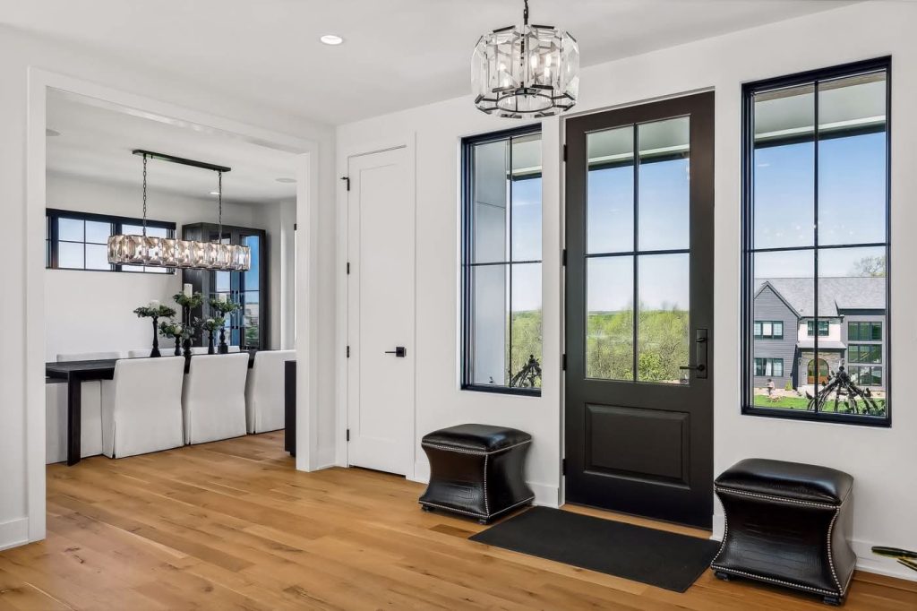 Modern entryway with black door and hardwood floors