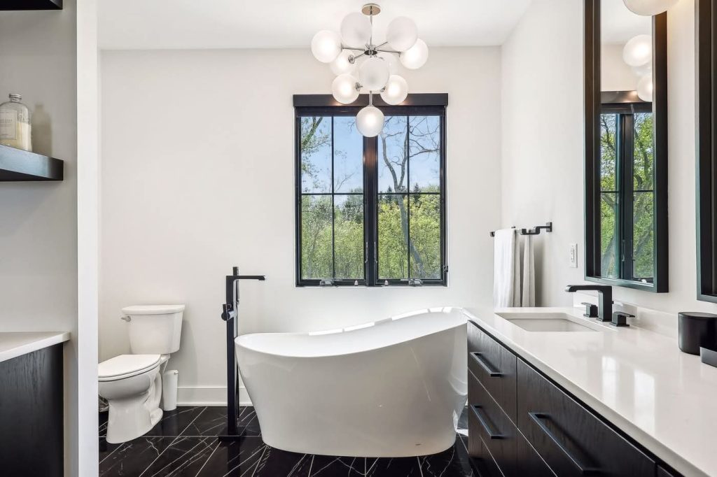 Modern bathroom with freestanding tub and large window