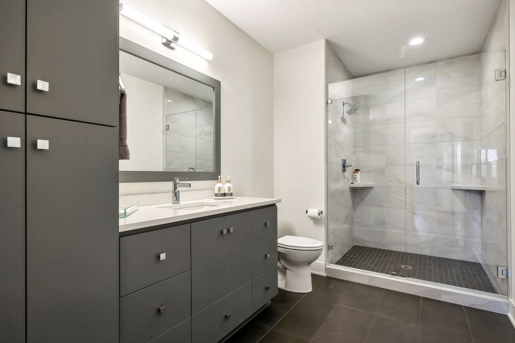 Modern bathroom with gray vanity and glass shower